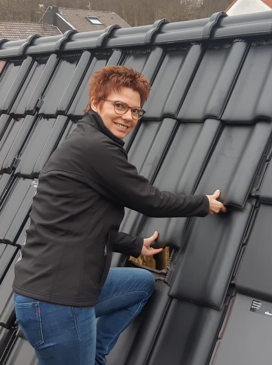 Das Foto zeigt Marion Meissner beim Verlegen von Dachschindeln.