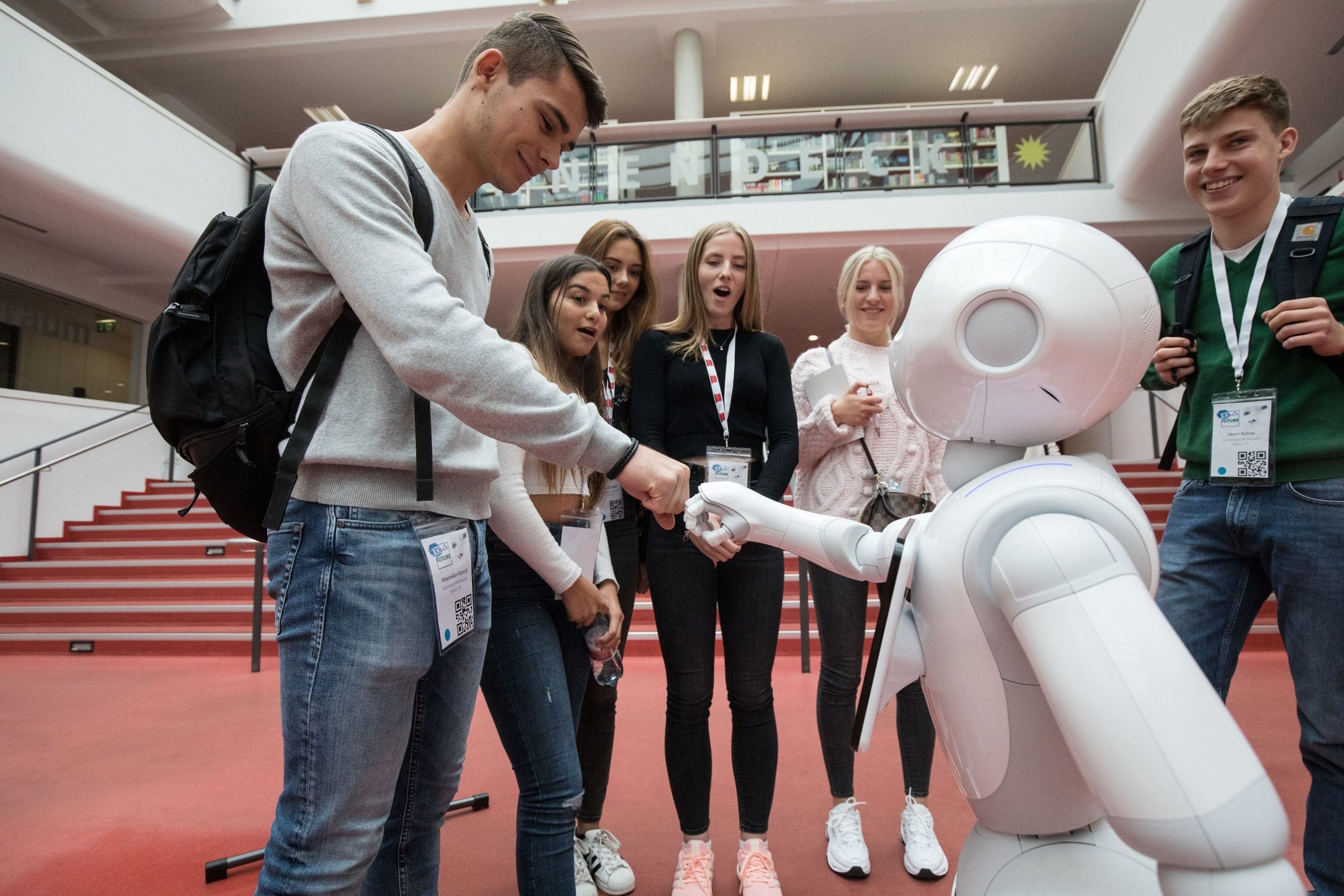 Jugendliche testen einen humanoiden Roboter auf einer MINT-Veranstaltung