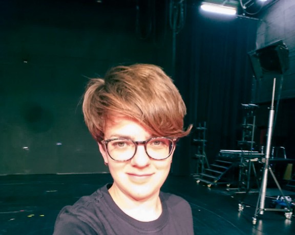 Das Foto zeigt Maria Sperl mit Bühnentechnik im Hintergrund.