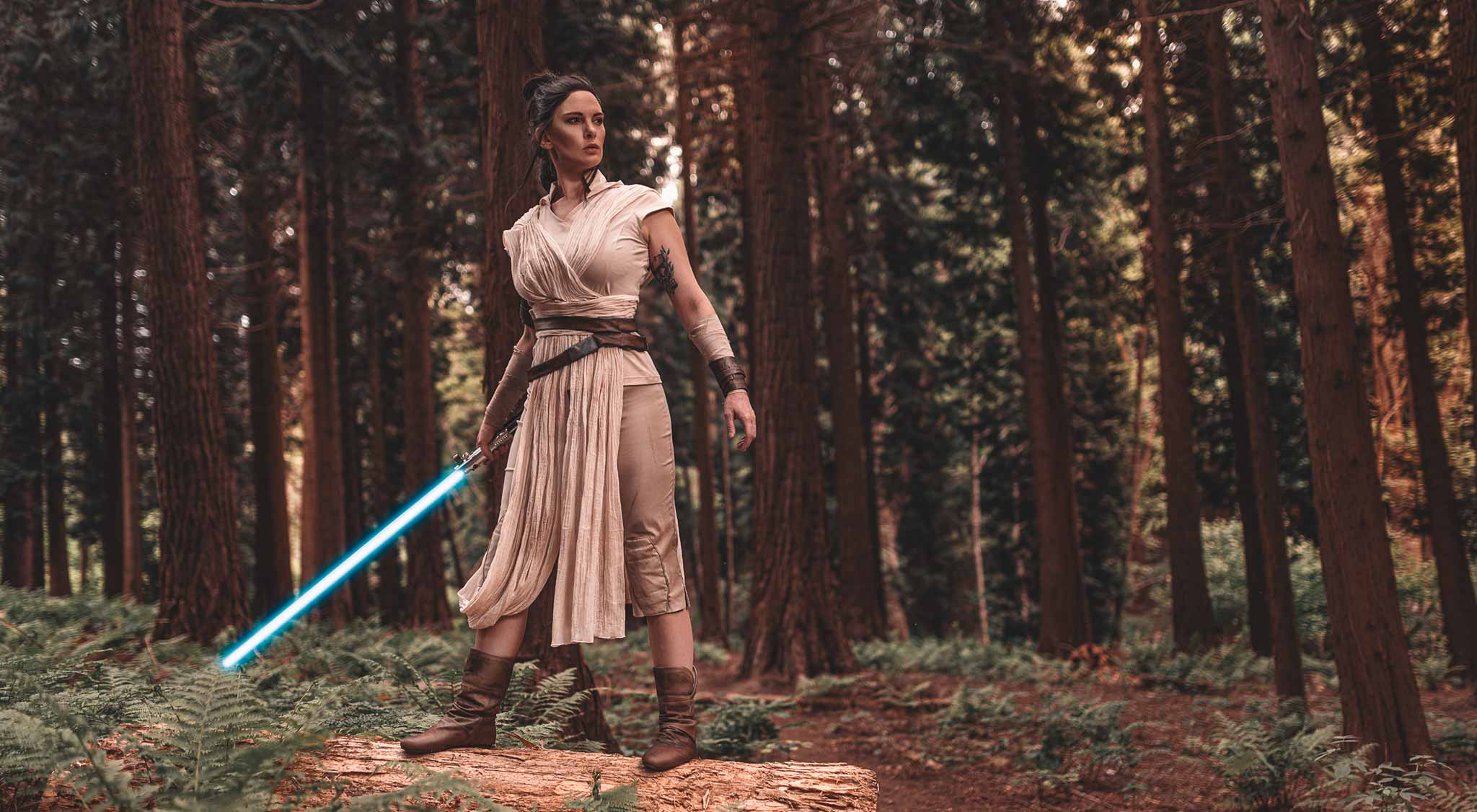 Das Bild zeigt eine Cosplayerin im Sternenkriegerinnen-Outfit mit einem Lichtschwert im Wald. Am Stand von zdi.NRW auf der Gamescom kann man auch Lichtschwerter anschauen.