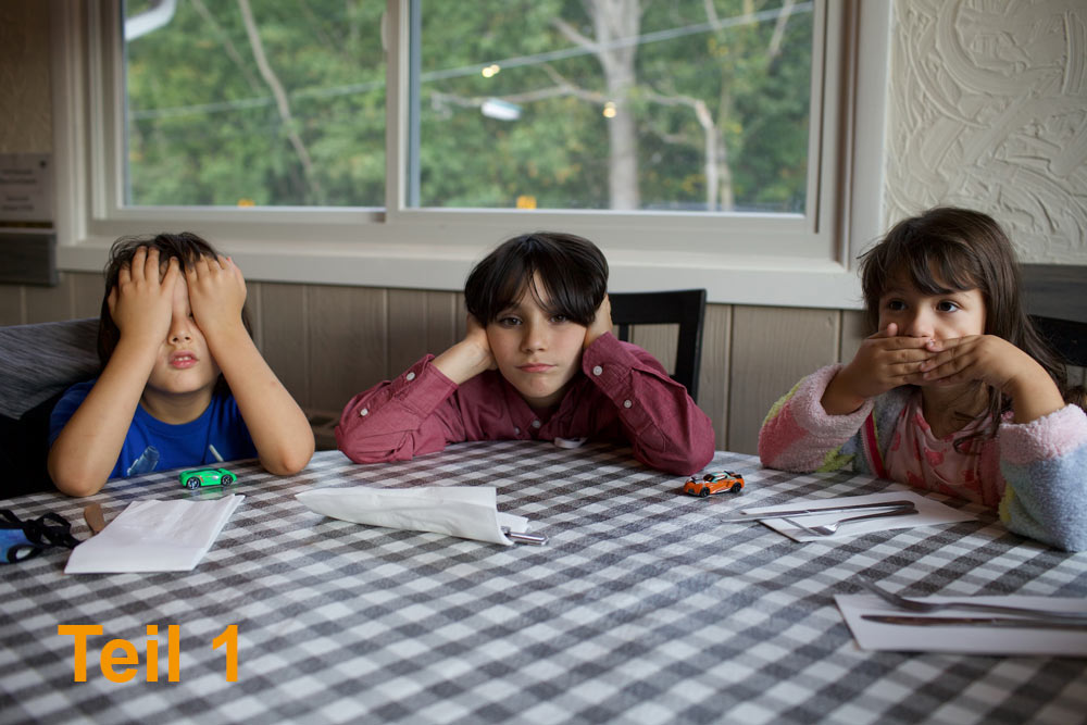 Das Foto hat eine dekorative Funktion. Es zeigt drei Kinder, die an einem Tisch sitzen. Das Linke hält sich die Augen zu, das Mittlere hält sich die Ohren zu, das Rechte hält sich den Mund zu. In der unteren linken Ecke steht "Teil 1".