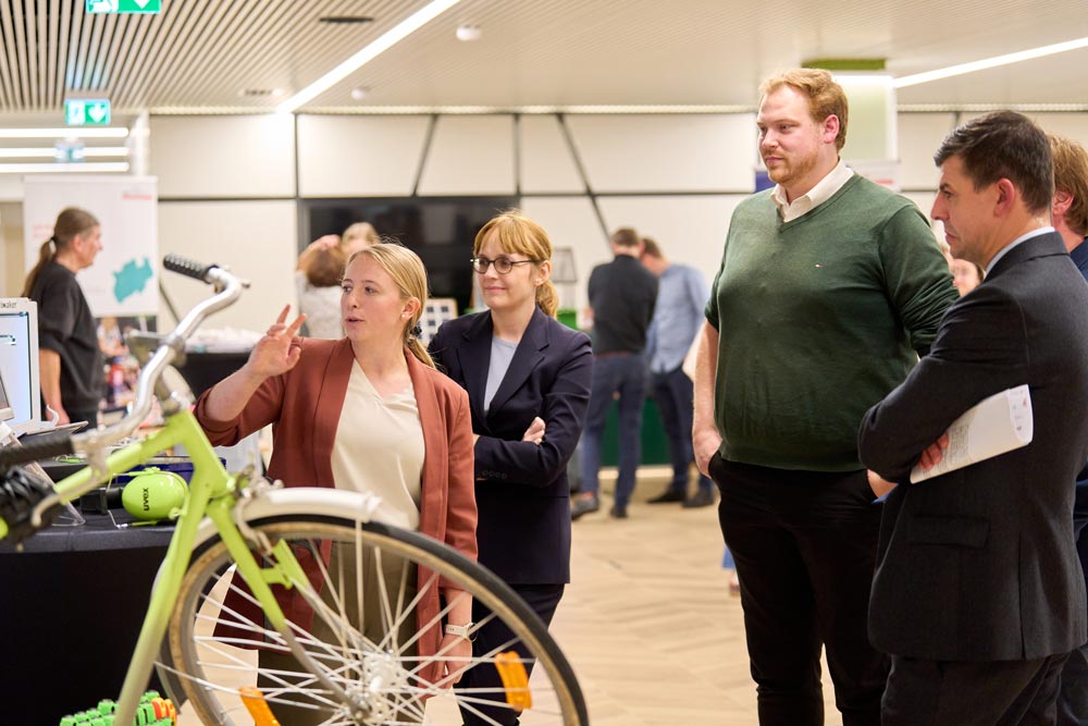 Eine Gruppe von Leuten schaut sich ein Fahrrad am Stand vom zdi-Netzwerk ANTalive an.