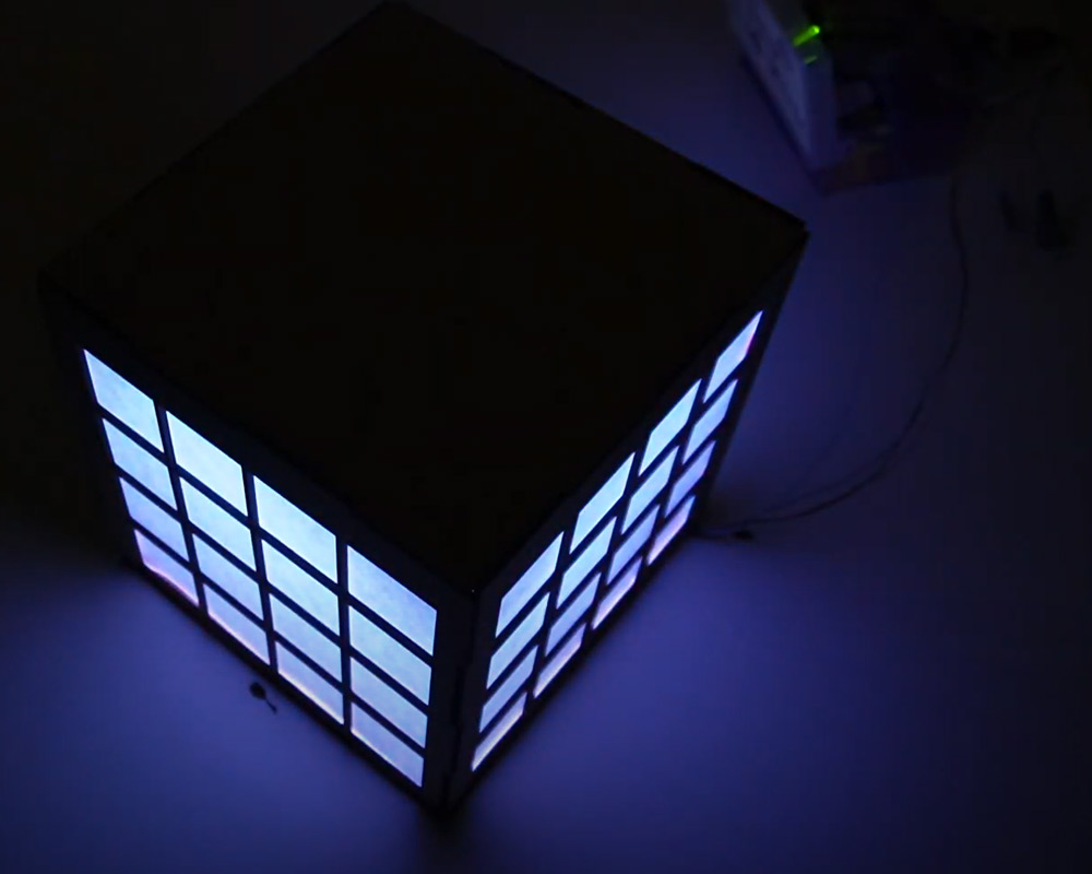 Das Modell eines Hauses mit vielen Fenstern und eingeschaltetem Licht.