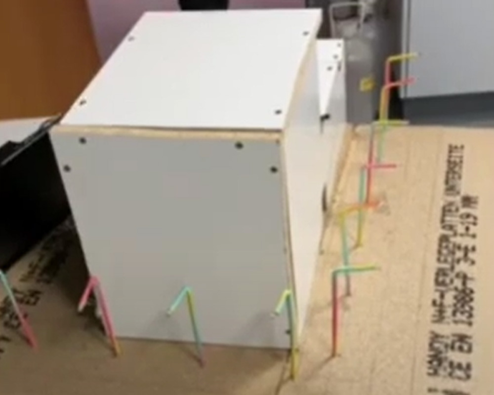 Ein Hausmodell mit ausgeschalteten Straßenlaternen.