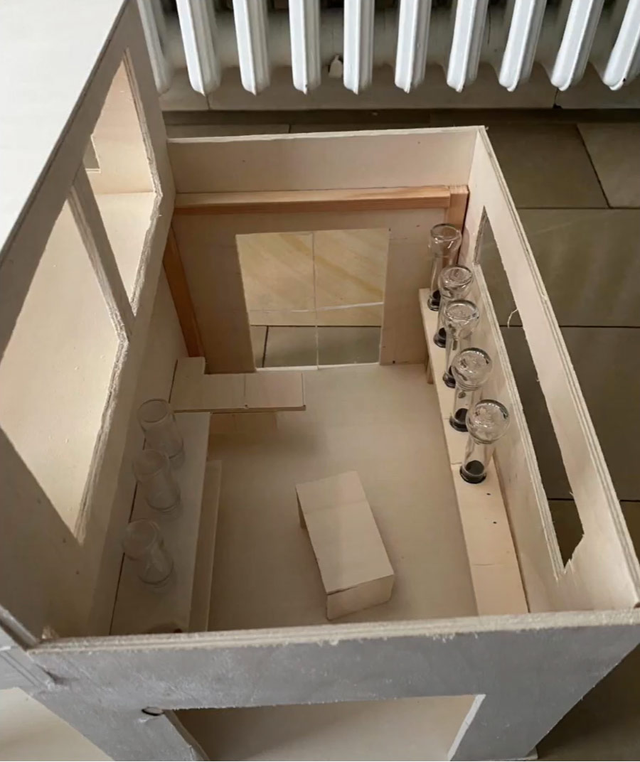 Ein Miniatur-Raummodell mit einem hölzernen Esstisch, Stühlen und Gläsern, die ordentlich angeordnet sind.