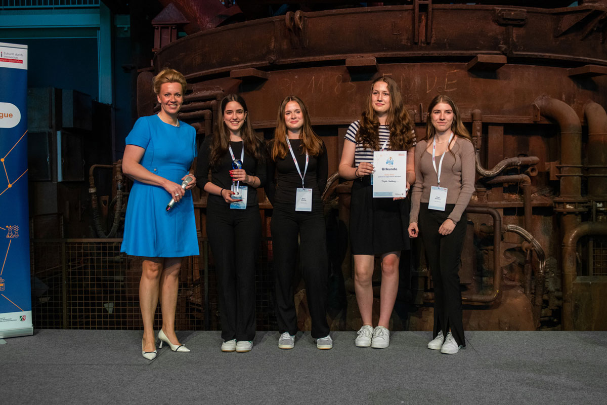 Ministerin Brandes mit den Gewinnerinnen bei der Preisübergabe auf der Bühne.
