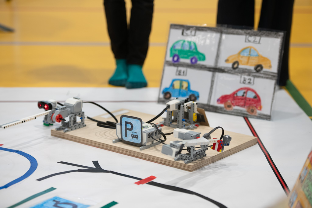 Das Bild zeigt eine Atrappe eines mit KI gesteuerten Parkhauses. Mehrere Roboter simulieren Fahrzeuge, die eingeparkt werden.
