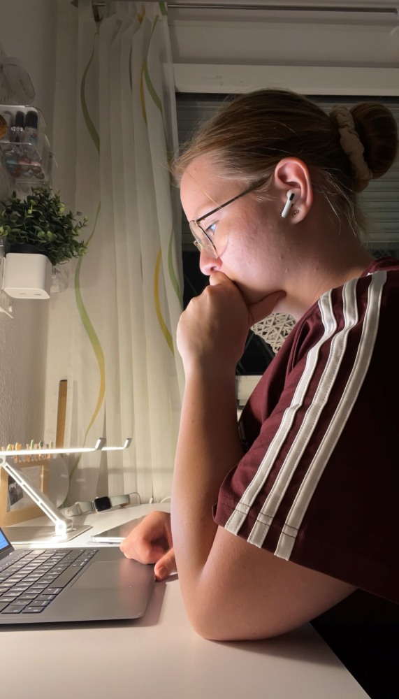 Person arbeitet konzentriert am Laptop am Schreibtisch