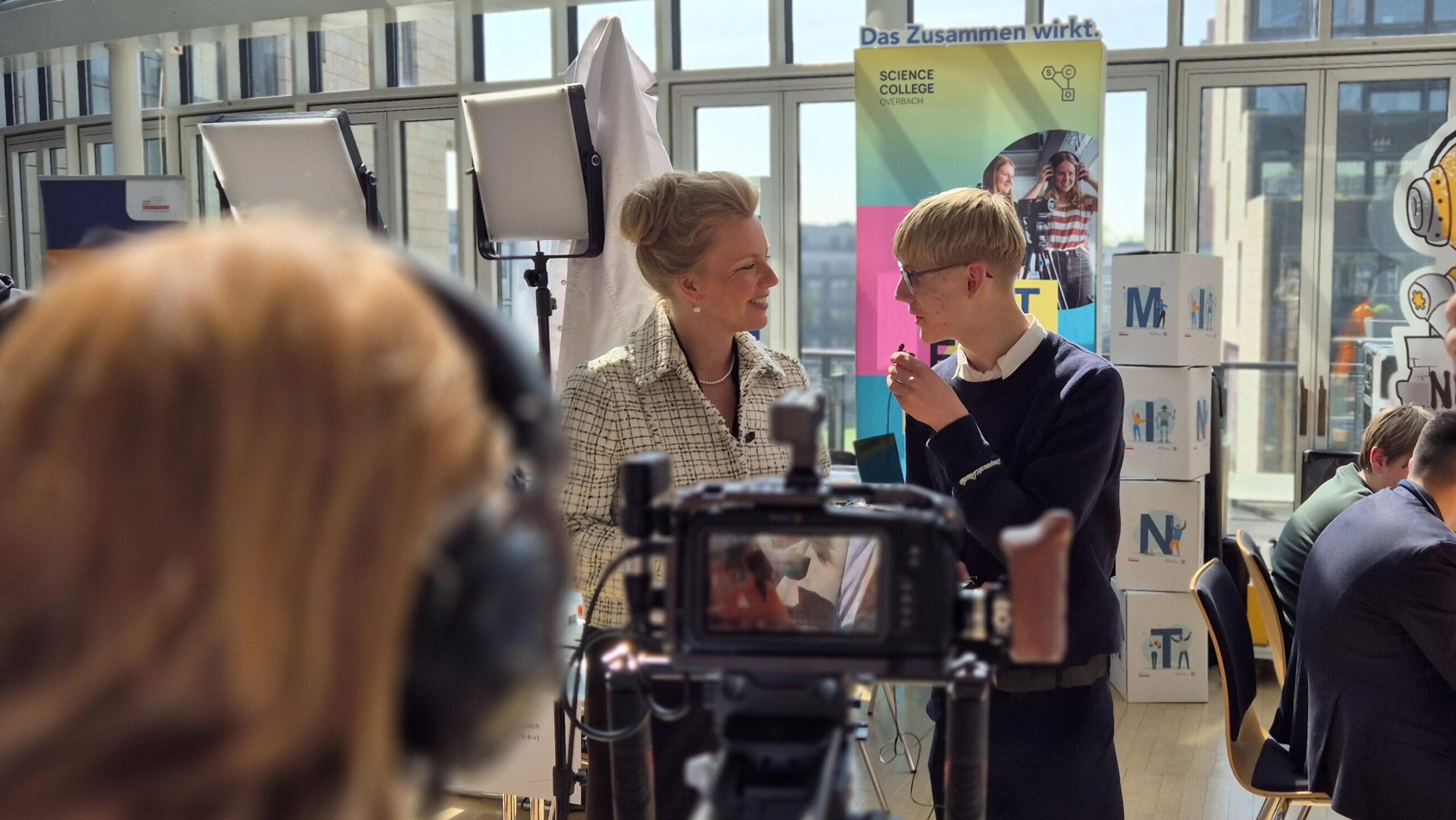 Interview im Science College Overbach mit Kamera- und Lichttechnik im Vordergrund