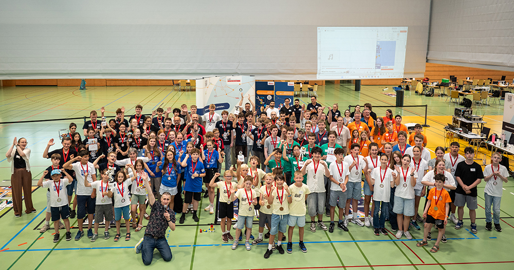 Gruppenfoto von vielen Teilnehmern mit Medaillen in einer Sporthalle